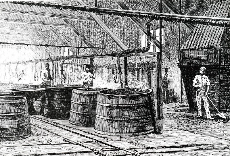 Historic black and white photo of two men producing detergent using traditional methods